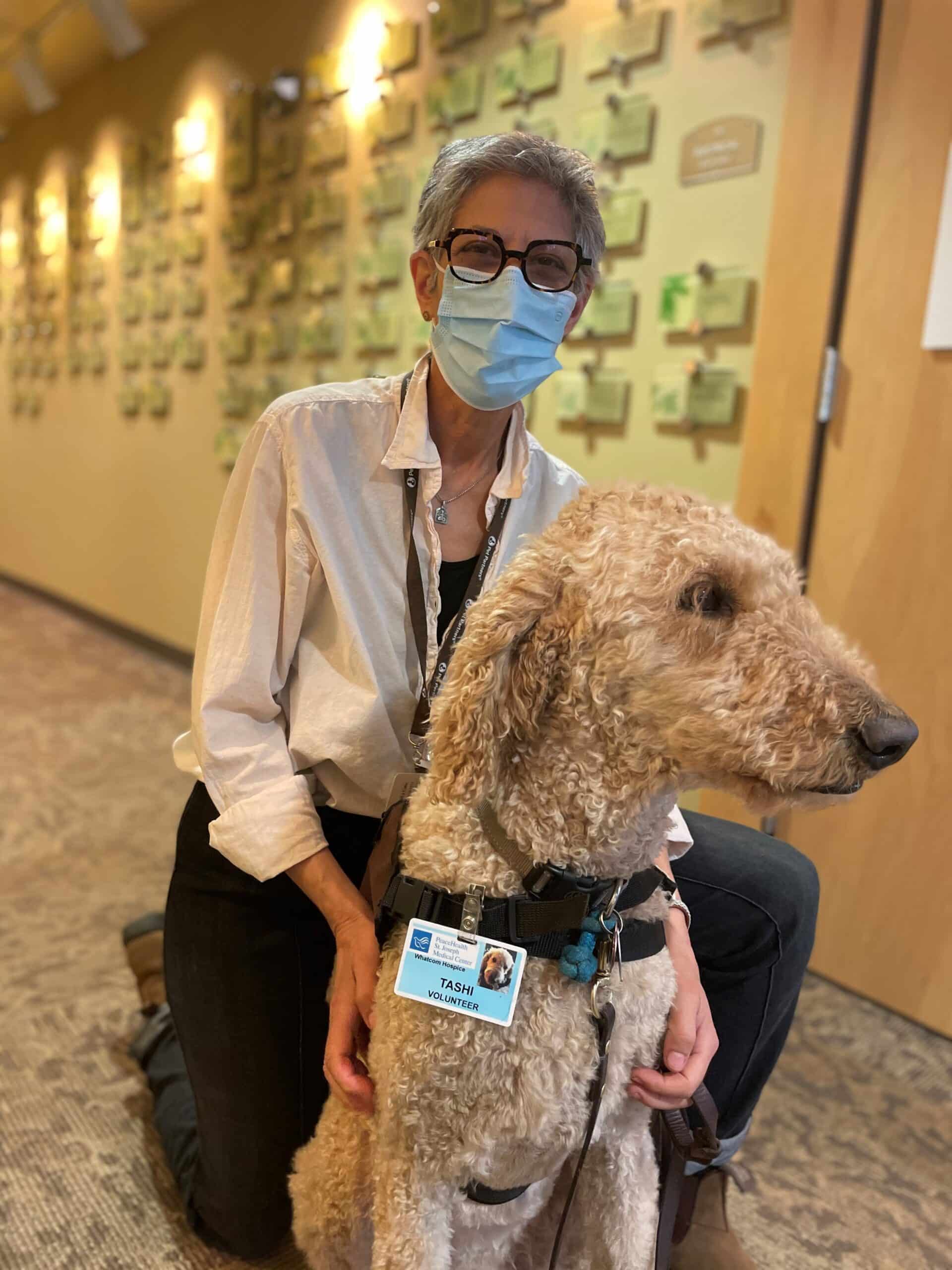 A therapy animal handler and her therapy dog in a common space at a hospice facility