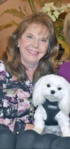 A therapy dog handler with her maltese therapy dog 