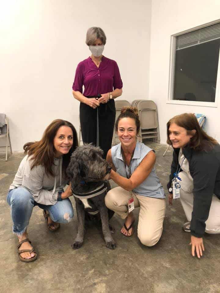 A therapy dog team poses with a team evaluator and evaluation assistants after their evaluation.