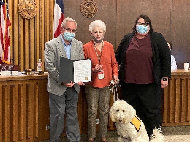 The mayor of Palestine, TX and the district attorney of Anderson County, TX with Pet Partners team Sharon Davis and Sophie presenting a proclamation in honor of National Therapy Animal Day 2021