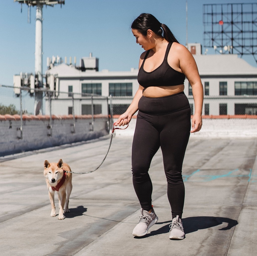 A woman exercising along with her dog