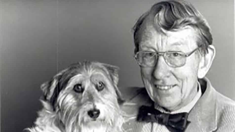 A black and white photo of Leo Bustad holding a small dog.