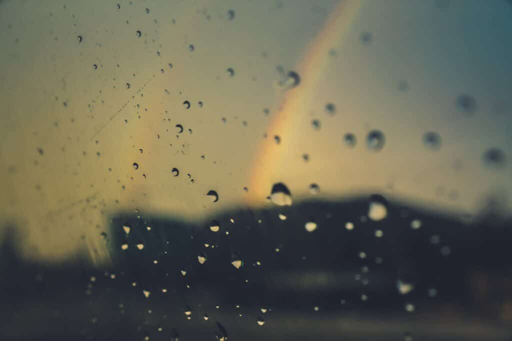 Image of a double rainbow through glass with raindrops on it. Photo by Isabelle Taylor from Pexels