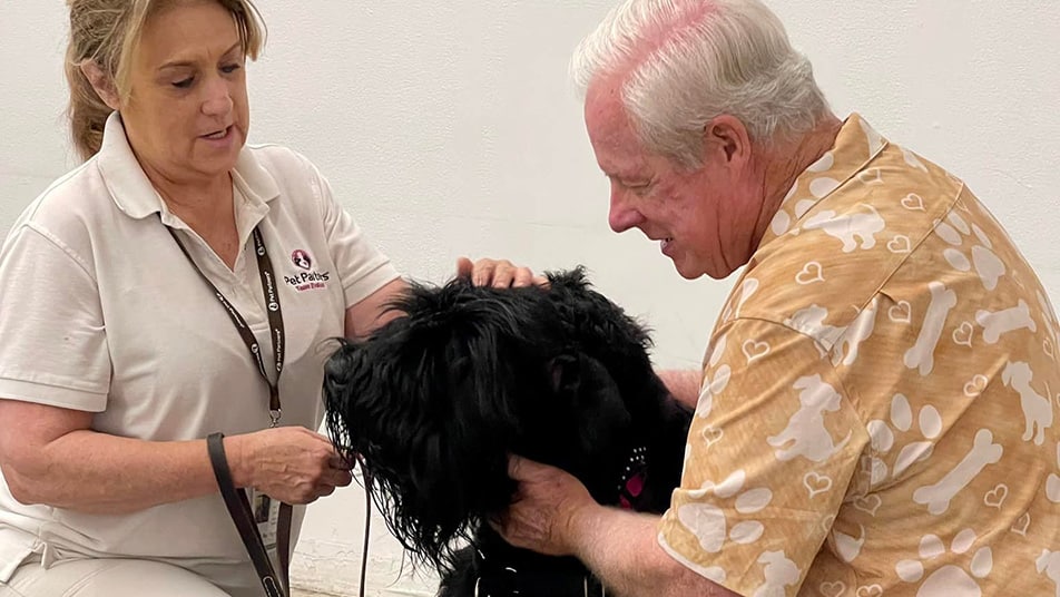 A Pet Partners volunteer evaluator helps a prospective team during an evaluation.