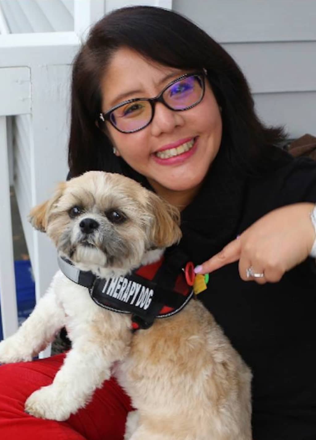 A handler poses with her small dog.