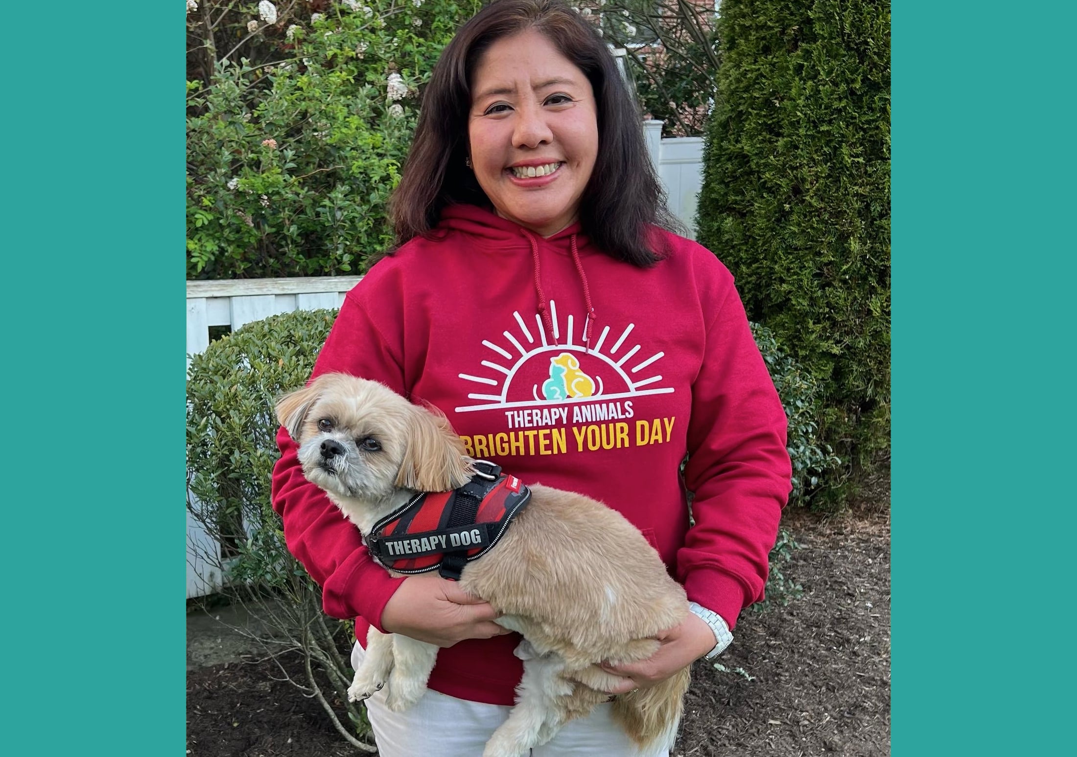 A handler poses with her small dog.