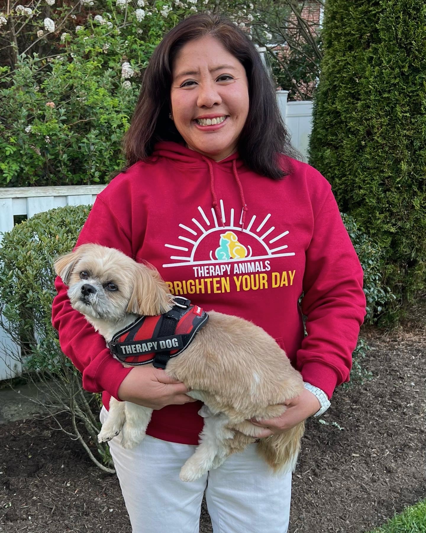 A handler poses with her small dog.