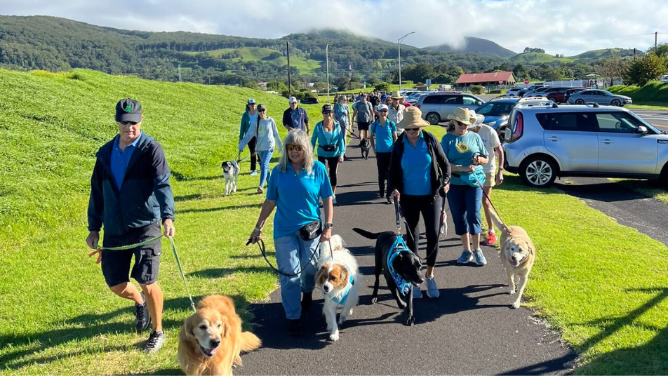 Hawaii residents walking dogs along a scenic path during the 2024 World’s Largest Pet Walk.