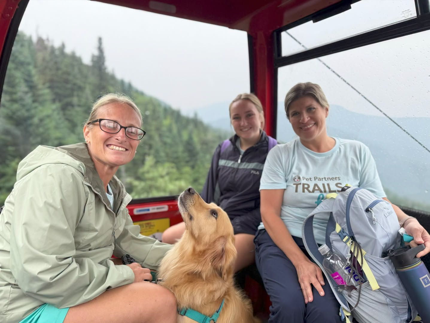 Three hikers and a therapy dog ride a gondola in Stowe, Vermont.